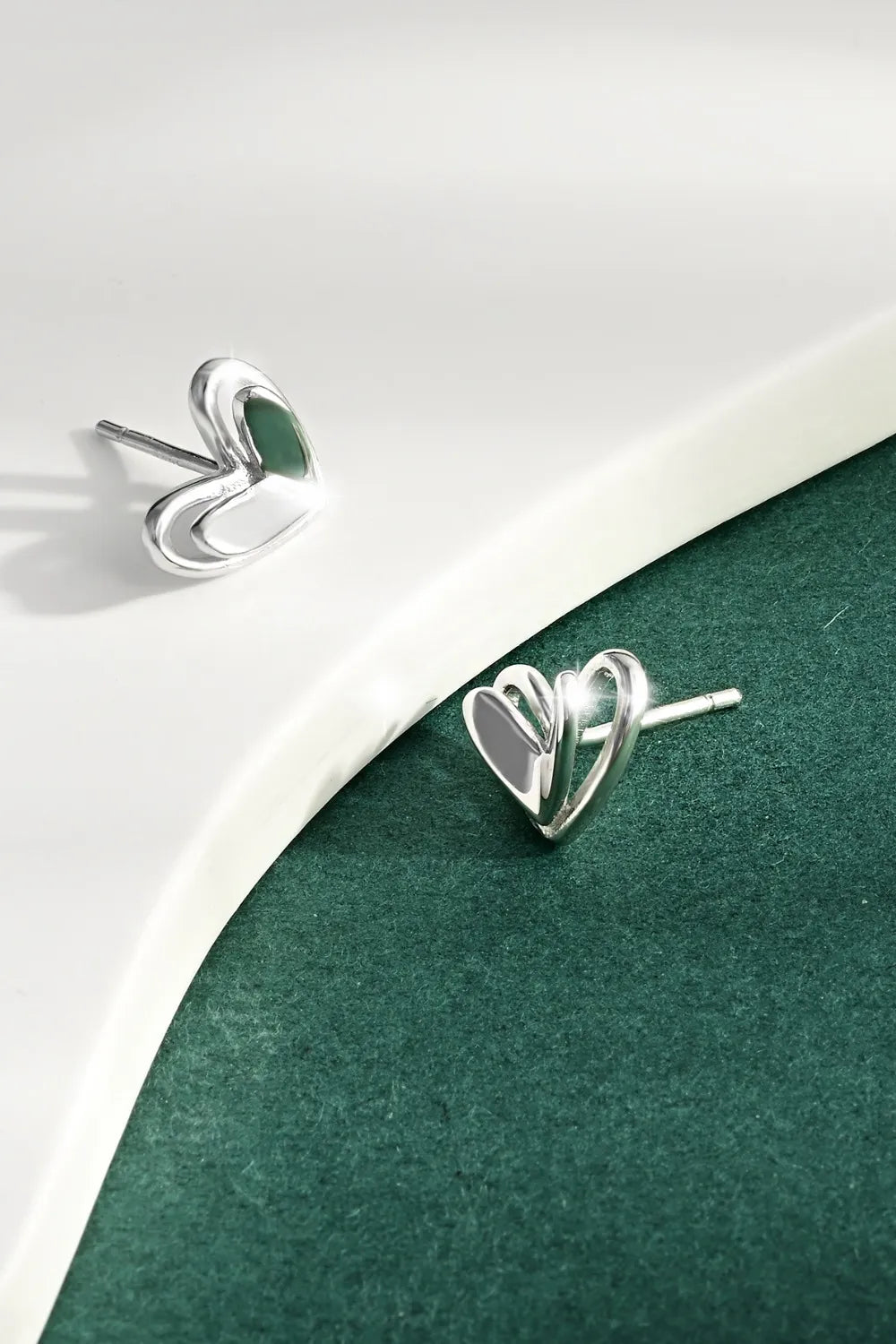 Silver open heart silhouette stud earrings with a delicate design.