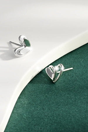 Silver open heart silhouette stud earrings with a delicate design.