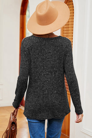 Black ribbed knit top with eyelet shoulder detail and long sleeves.