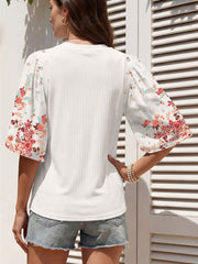 White ribbed half sleeve top with floral print sleeves and a crew neck.