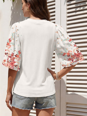 White ribbed half sleeve top with floral print sleeves and a crew neck.