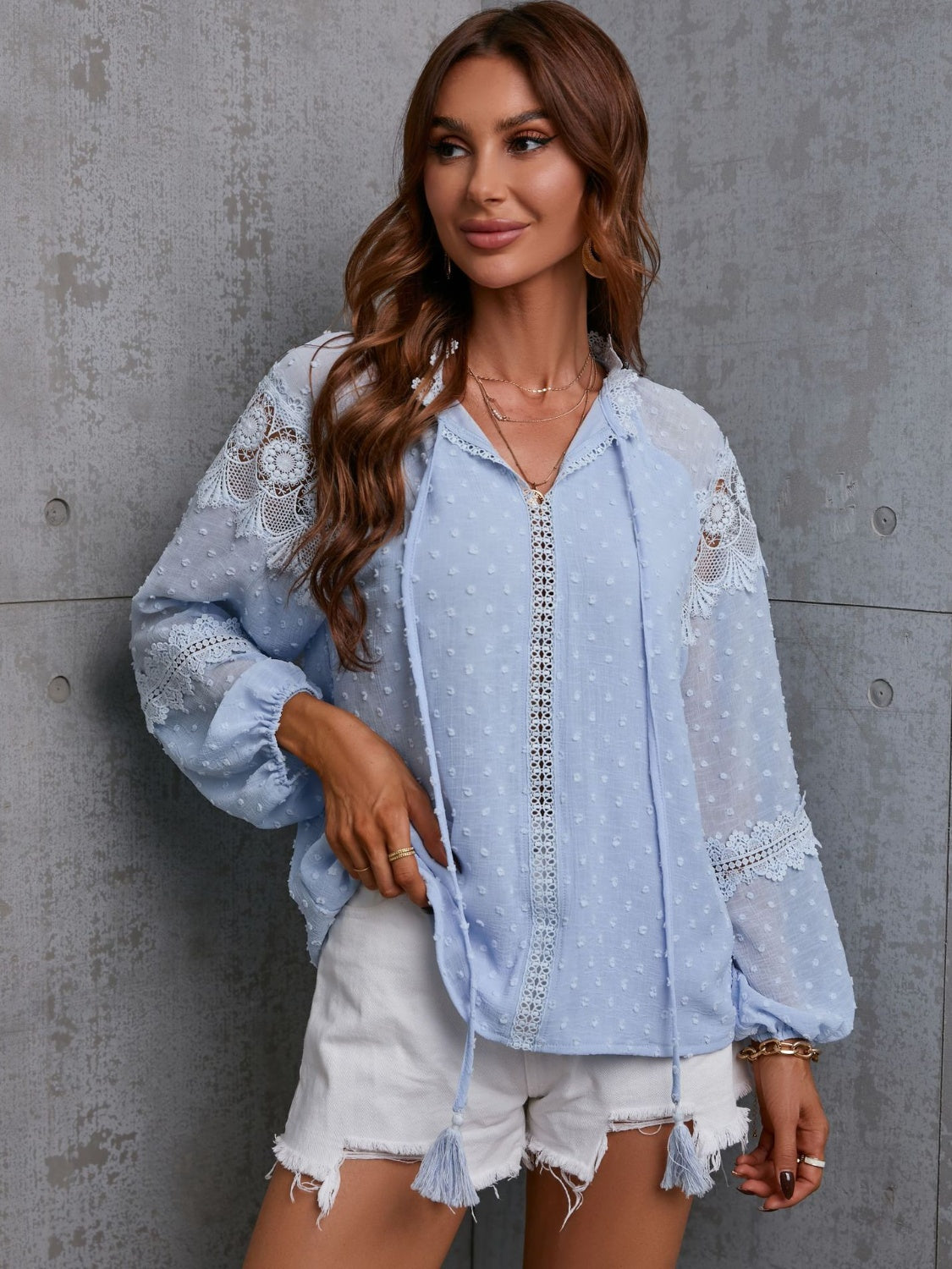 Misty blue textured blouse with lace trim and tie neck detail, long sleeves.