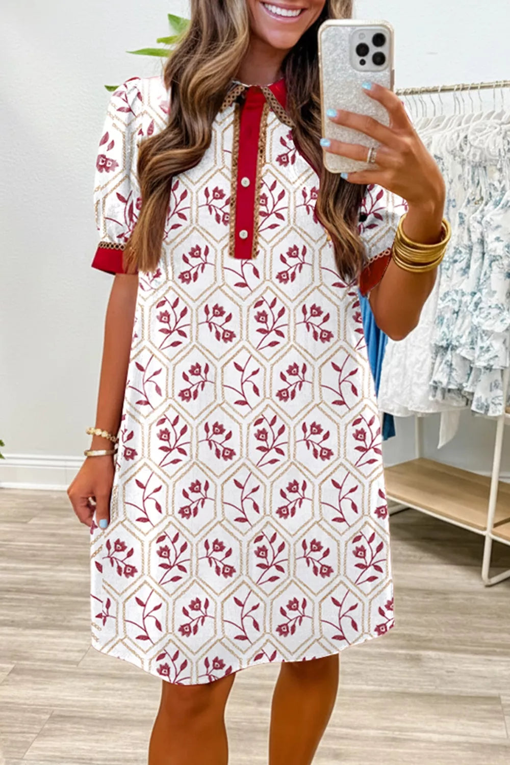 Floral print short sleeve dress with button-down collar and red trim.