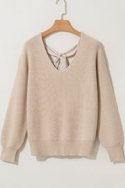 Beige ribbed knit sweater with V-neck and back bow detail