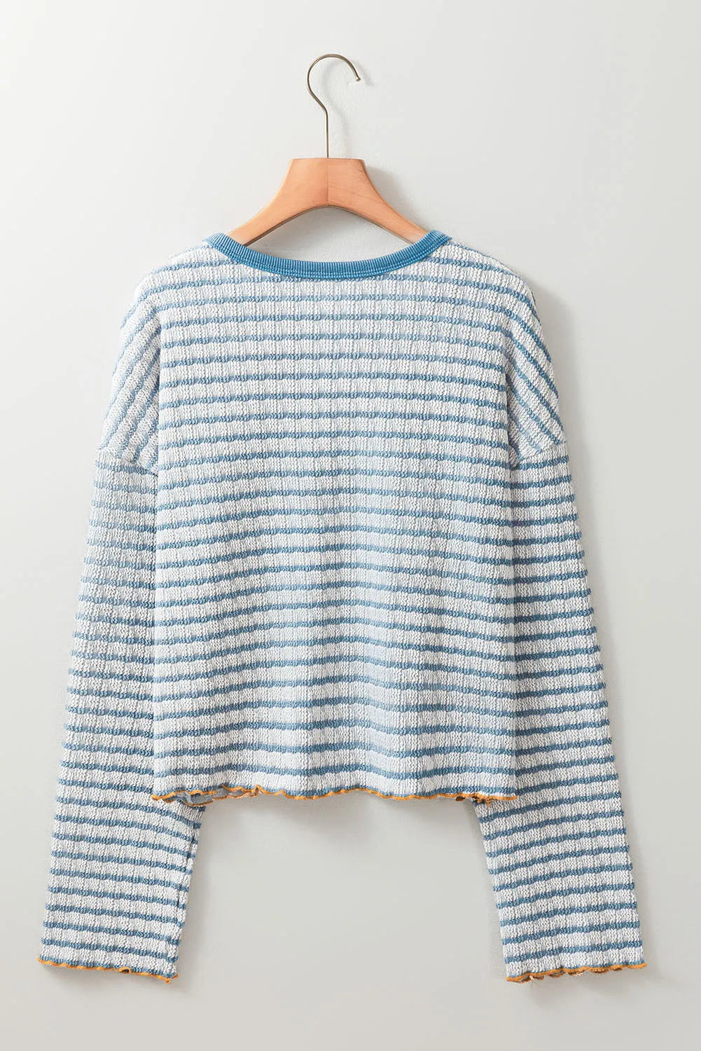 Textured stripe henley sweater in dusty blue with a crew neck and lettuce hem detail.