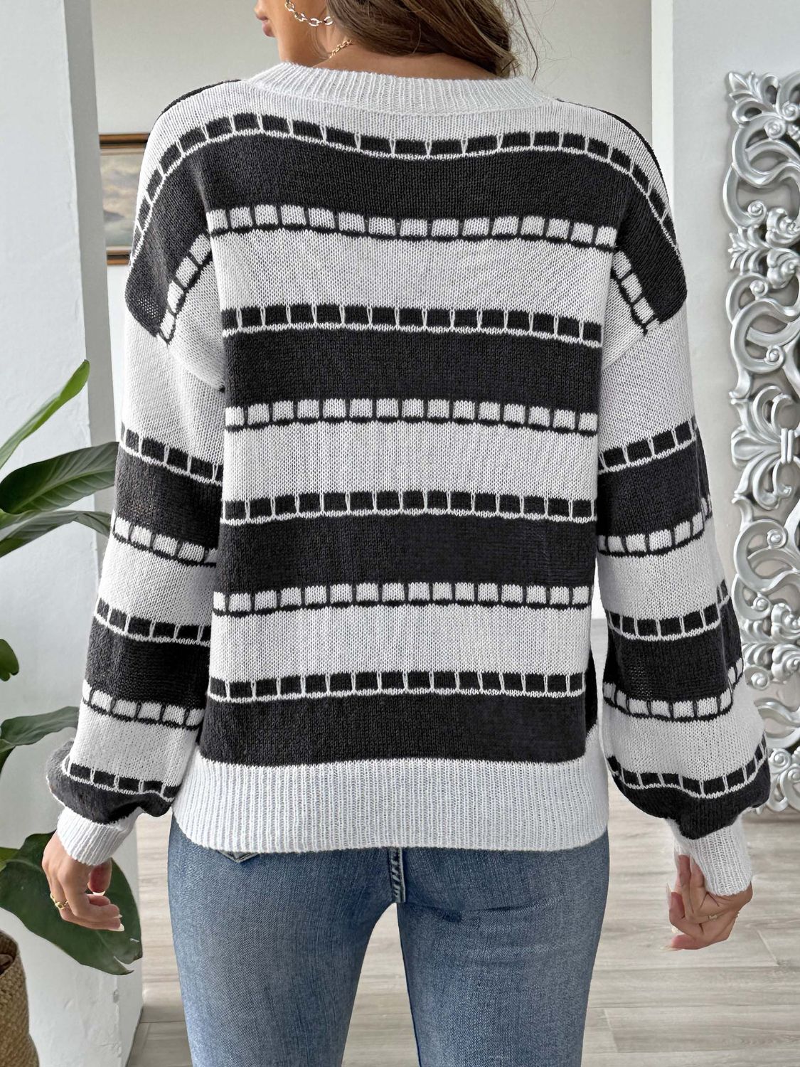 Black and white striped knit sweater with embroidered detail, crew neck, long sleeves.