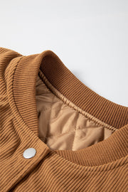 Terracotta corduroy bomber jacket with quilted lining and ribbed collar.