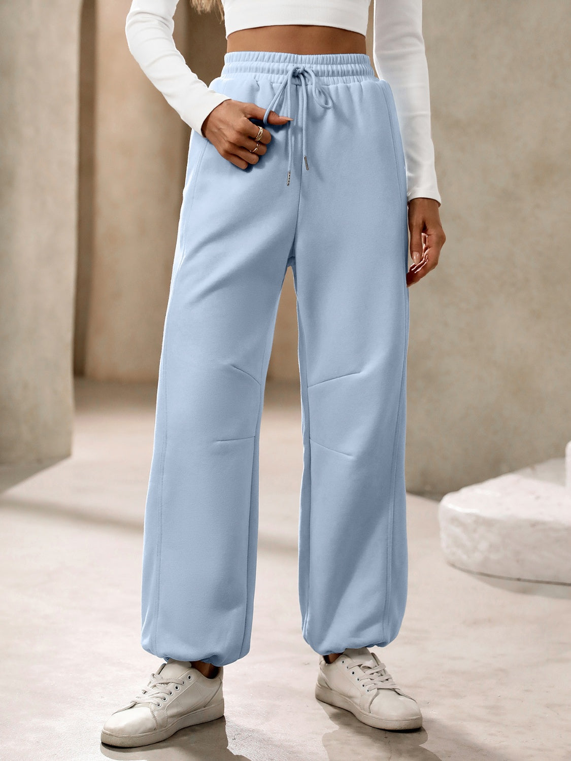 Light blue balloon-leg sweatpants with drawstring waist and cuffed ankles.