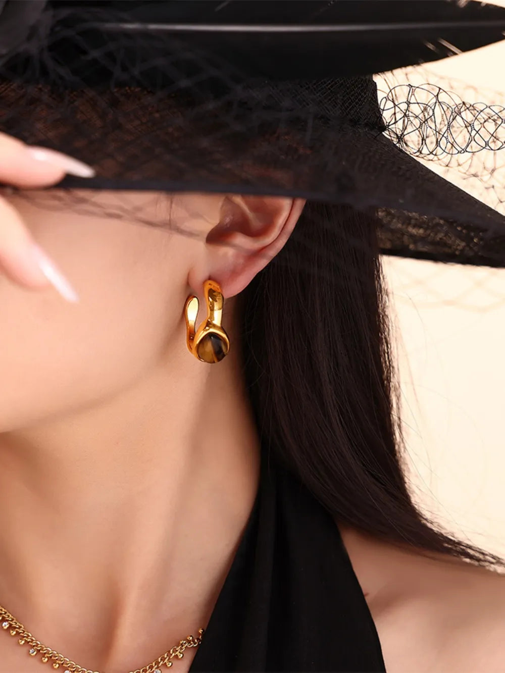 Gold hoop earrings with tiger's eye stone detail, part of a sculptural duo set.