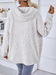 Textured knit zip-up hoodie in white with speckles, featuring a logo detail on the sleeve.