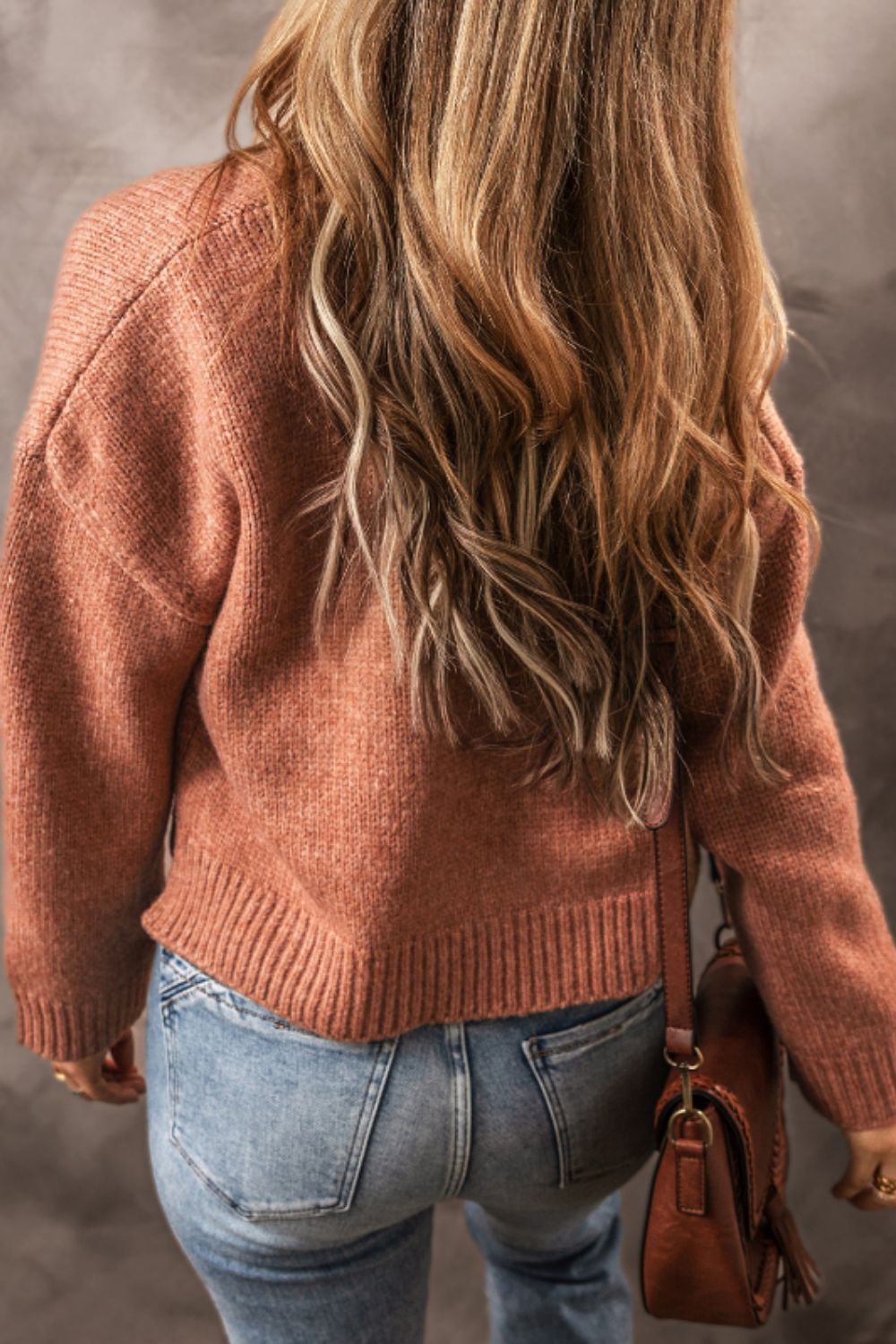 Open-front cropped knit cardigan in burnt coral acrylic with ribbed hem and cuffs.