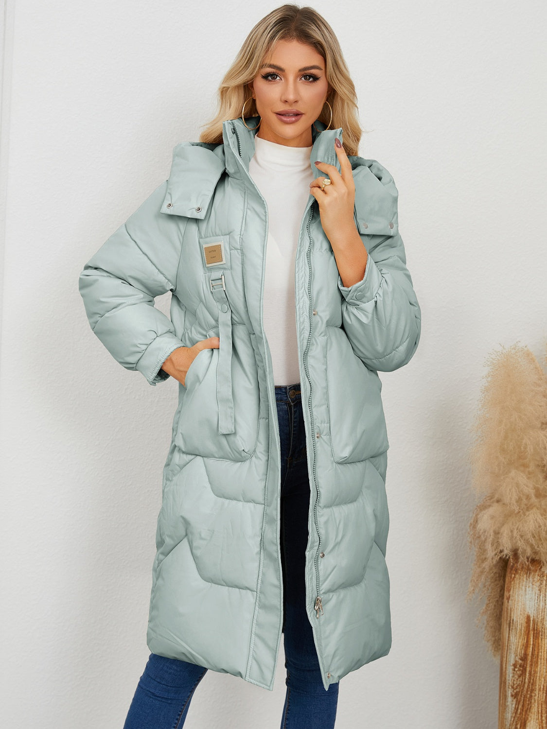 Sage quilted puffer parka with buckle detail and drawstring waist.