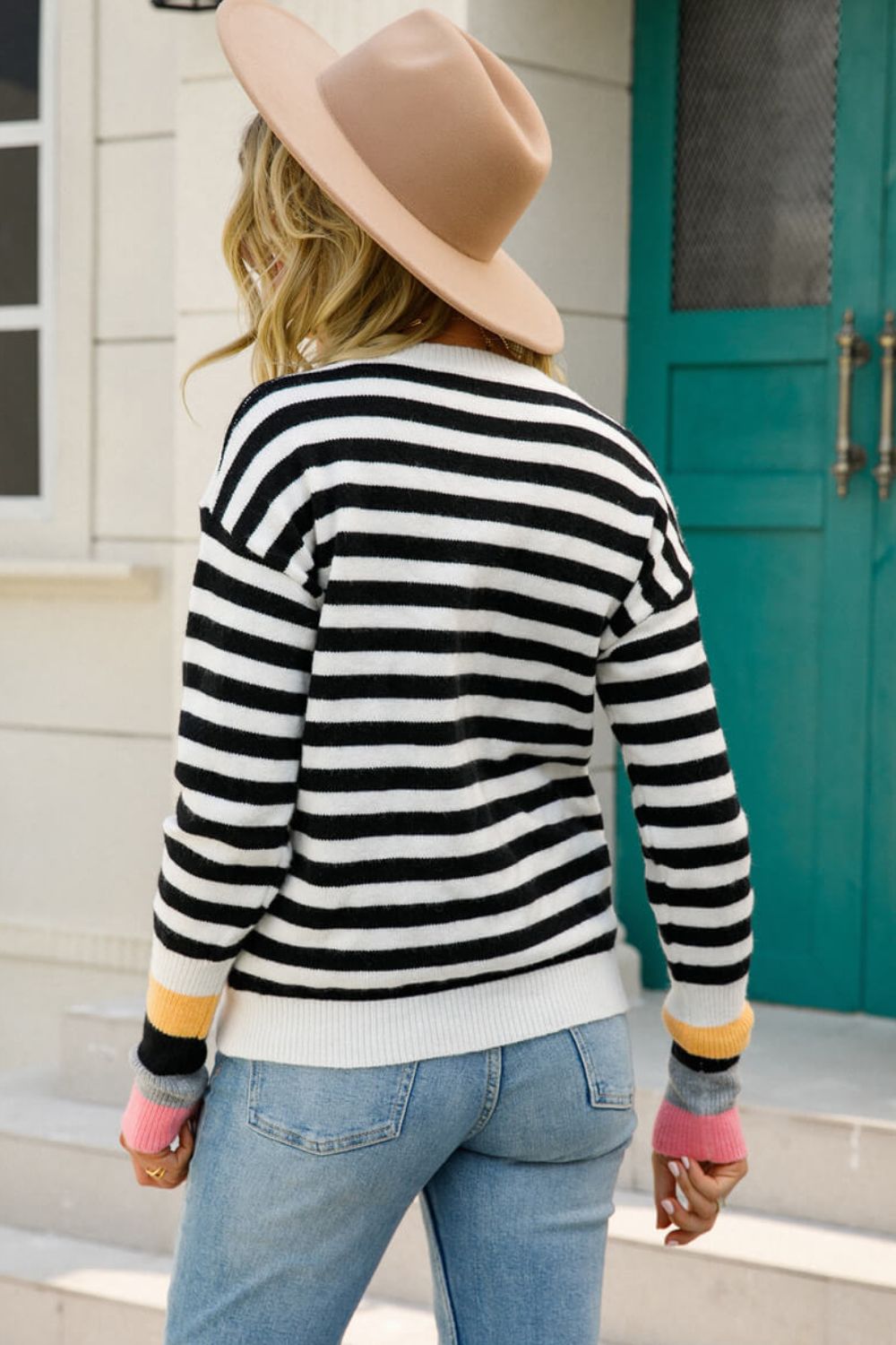 Acrylic sweater with black and white stripes and colorful cuffs.