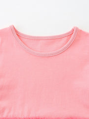 Pink cotton baby dress with a round neckline and ruffled hem detail.