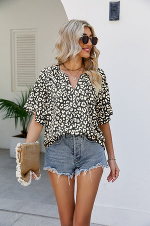 Black leopard print v-neck blouse with short sleeves and a relaxed fit.