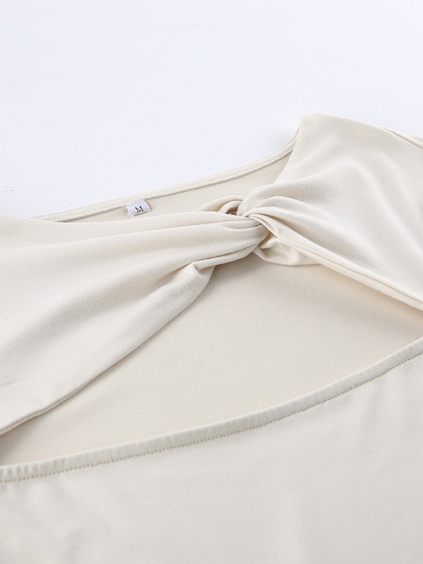 Beige knot front cutout long-sleeve shirt with a body-hugging fit.