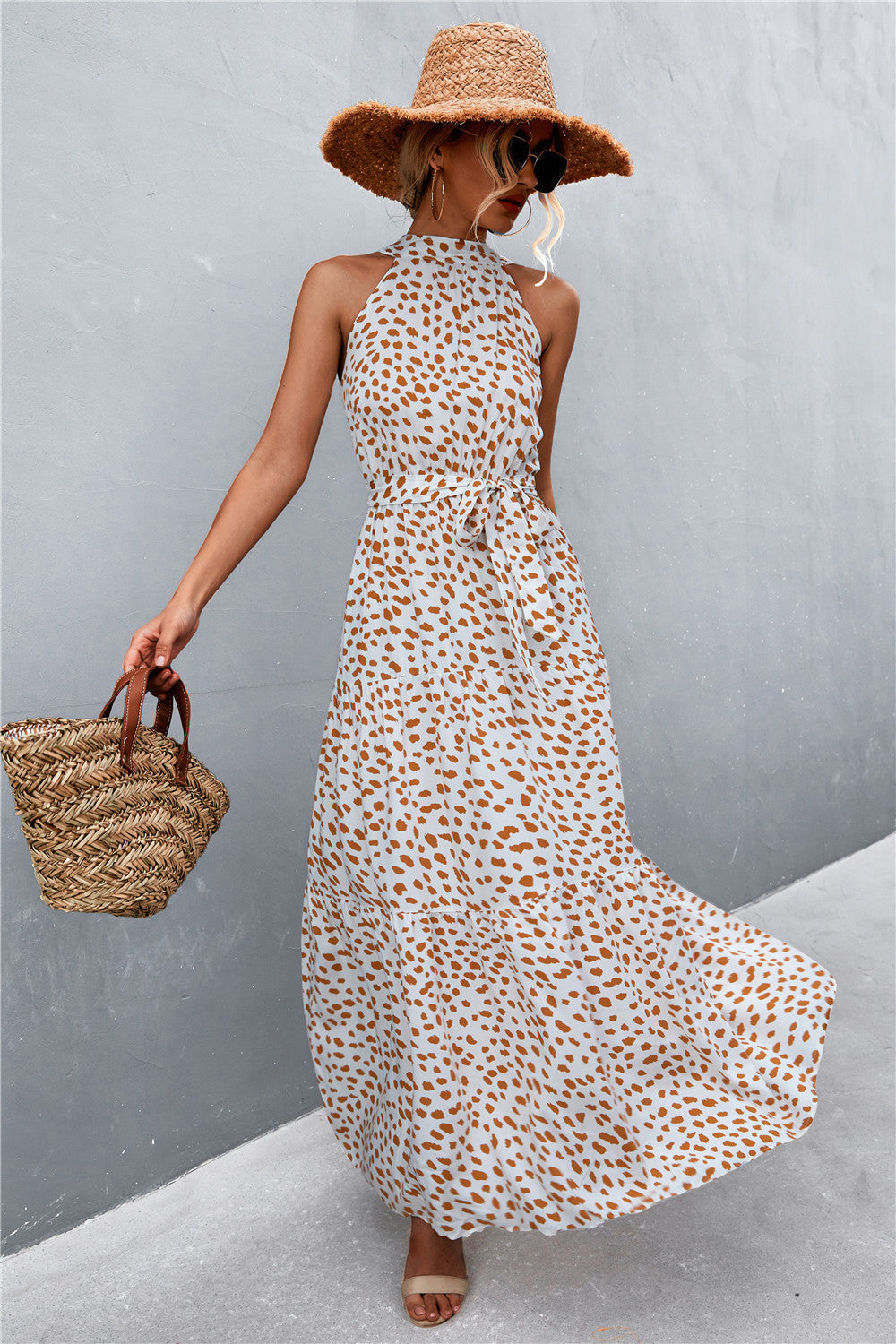 Maxi dress with halter neckline, tie waist, and orange animal print on white.