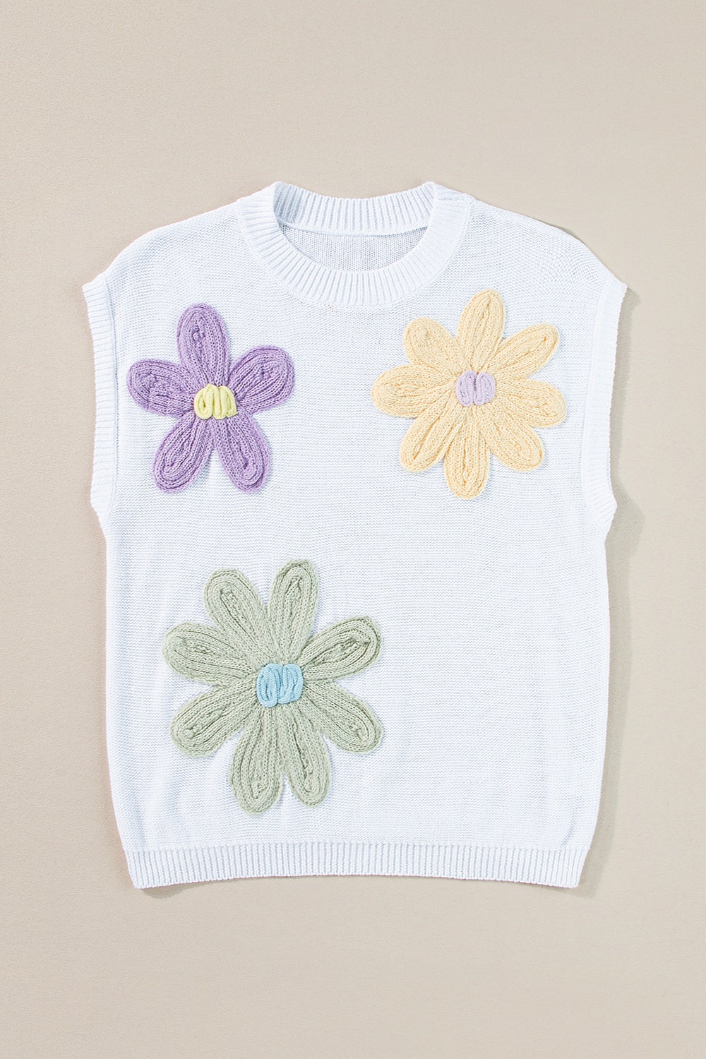 White knit sleeveless top with embroidered purple, yellow, and green flowers.