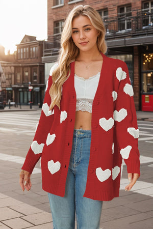 Red acrylic cardigan with white heart appliqués and buttons.