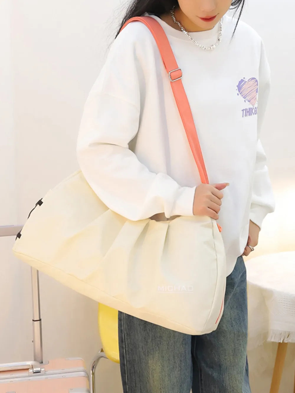 Gathered pleat crossbody bag in beige with adjustable coral strap.