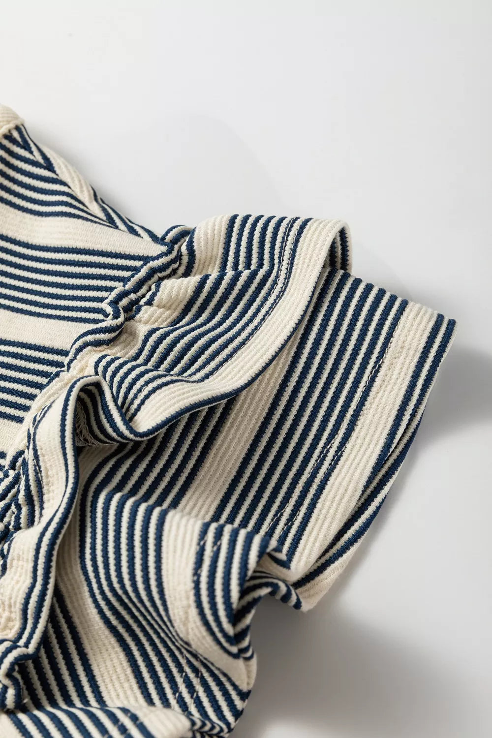 Navy and cream striped midi dress with ruffled details and buttoned front.