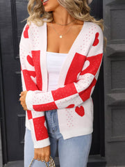 White and red heart motif knit cardigan with checkered sleeves and open front.