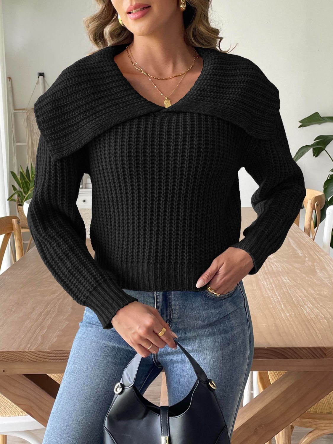 Black ribbed knit sweater with a dramatic shawl collar and long sleeves.