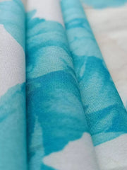 Teal floral print maxi dress fabric detail with V-neck and ruffle sleeve style.