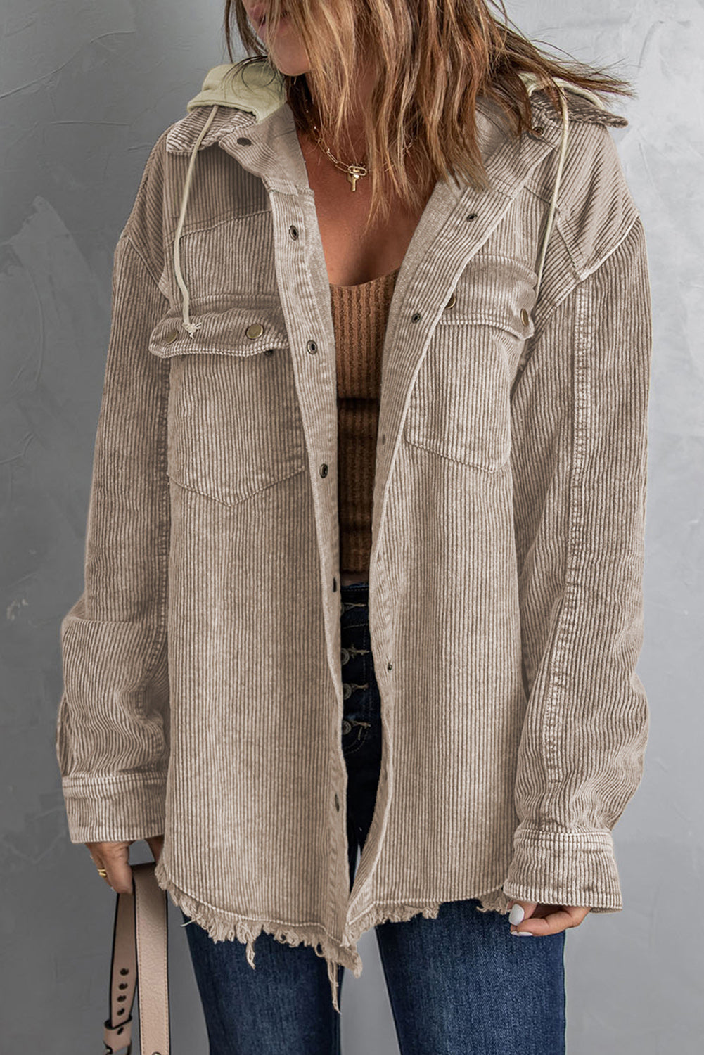 Tan corduroy hooded utility jacket with frayed hem and chest pockets.