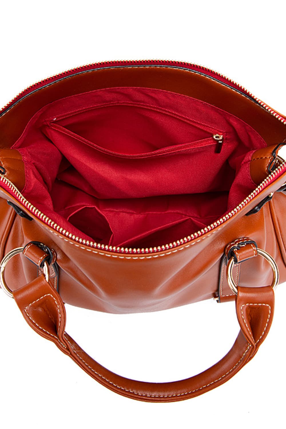Caramel structured satchel bag interior with red lining, zip pocket, and multiple compartments.