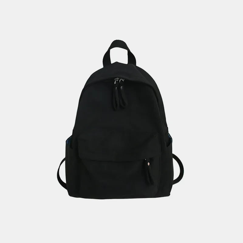 Black canvas school backpack with dual front pockets and zipper closures.