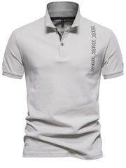 Gray piqué polo shirt with chevron embroidery detail on the chest and sleeve.