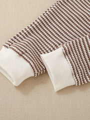 Baby knit set with brown and white stripes and white ribbed cuffs.