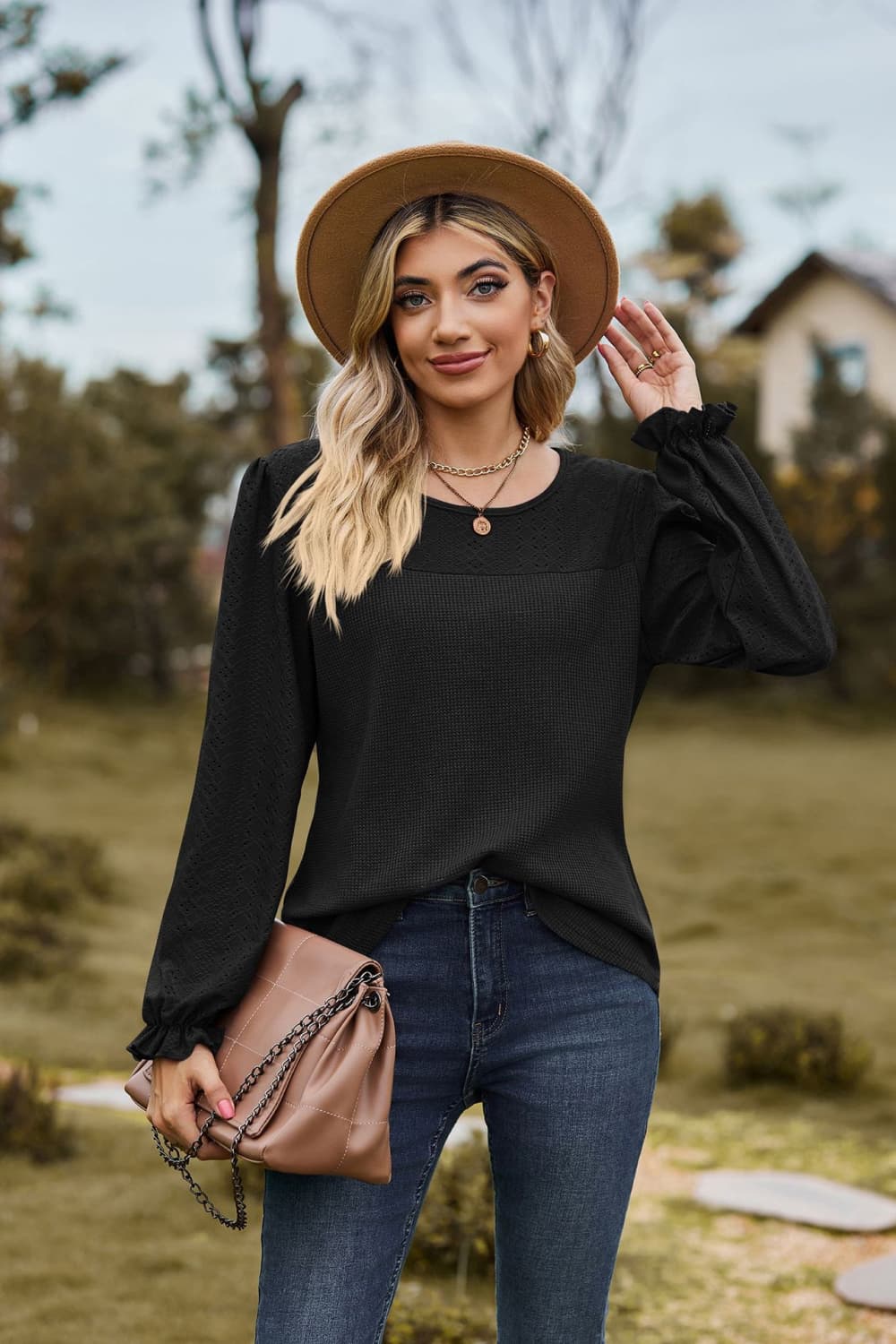 Black waffle knit blouse with perforated yoke and ruffled cuffs