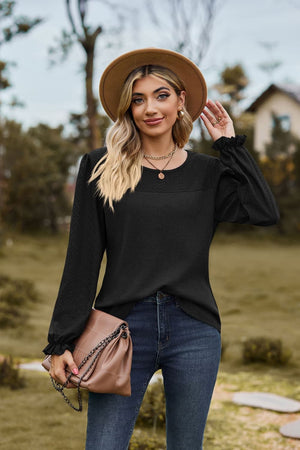 Black waffle knit blouse with perforated yoke and ruffled cuffs
