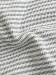 Baby one-piece with grey and white horizontal stripes in waffle knit fabric.