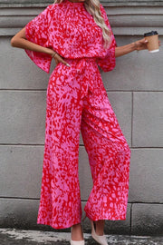 Crimson Splatter Tie-Waist Palazzo Jumpsuit in hot pink with wide legs and flutter sleeves.