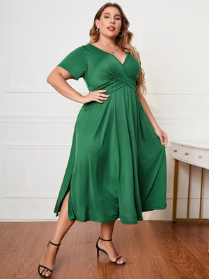 Emerald green midi dress with twist-front detail and side slits.