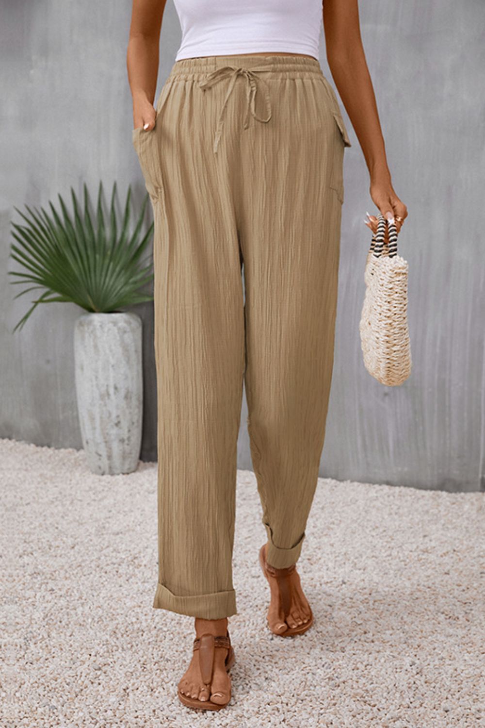 Khaki textured trousers with drawstring waist and cuffed hems
