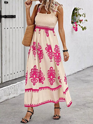 Smocked square neck maxi dress in tan with pink floral print, a-line cut, and ruffled straps.