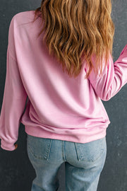 Blush pink crewneck sweatshirt with long sleeves, casual fit, styled with jeans.