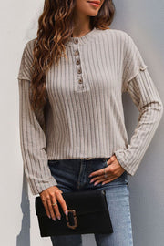 Tan ribbed henley shirt with button detail and flared sleeves.