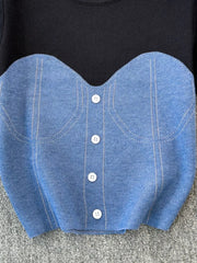 Color block knit t-shirt in black with a blue ribbed bustier detail and white buttons.