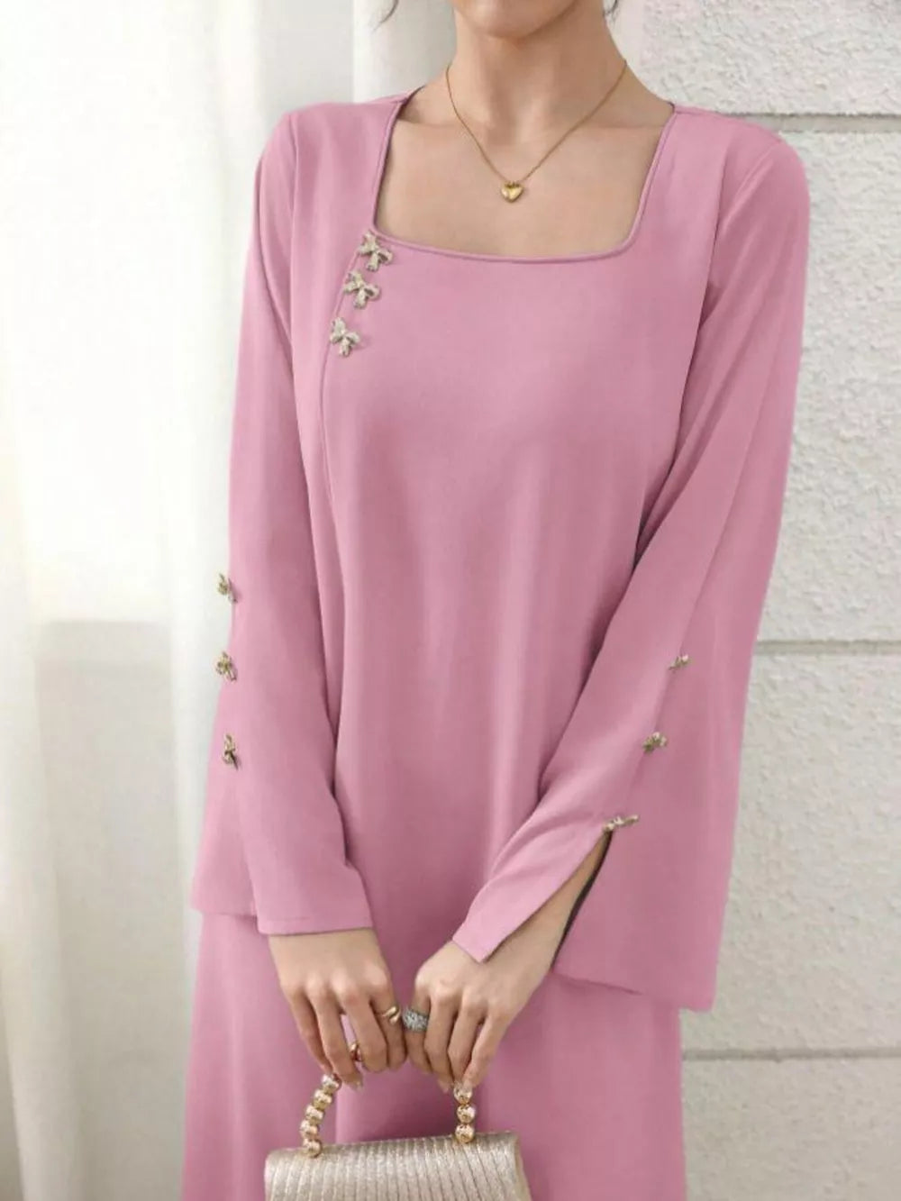 Pink maxi dress with square neckline, long sleeves, and decorative buttons.
