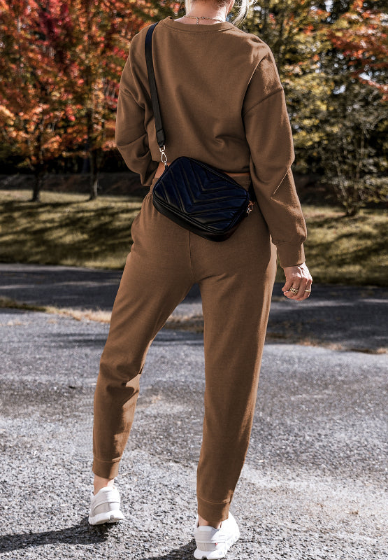 Relaxed fit lounge set in coffee brown, featuring a crewneck sweatshirt and jogger pants with side slits.