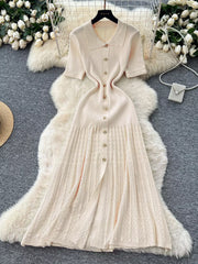 Apricot knit Peter Pan collar dress with gold buttons and a pleated skirt.