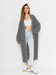 Oversized gray ribbed knit maxi cardigan with long sleeves and an open front, styled with a white crop top and jeans.