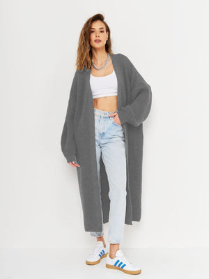 Oversized gray ribbed knit maxi cardigan with long sleeves and an open front, styled with a white crop top and jeans.