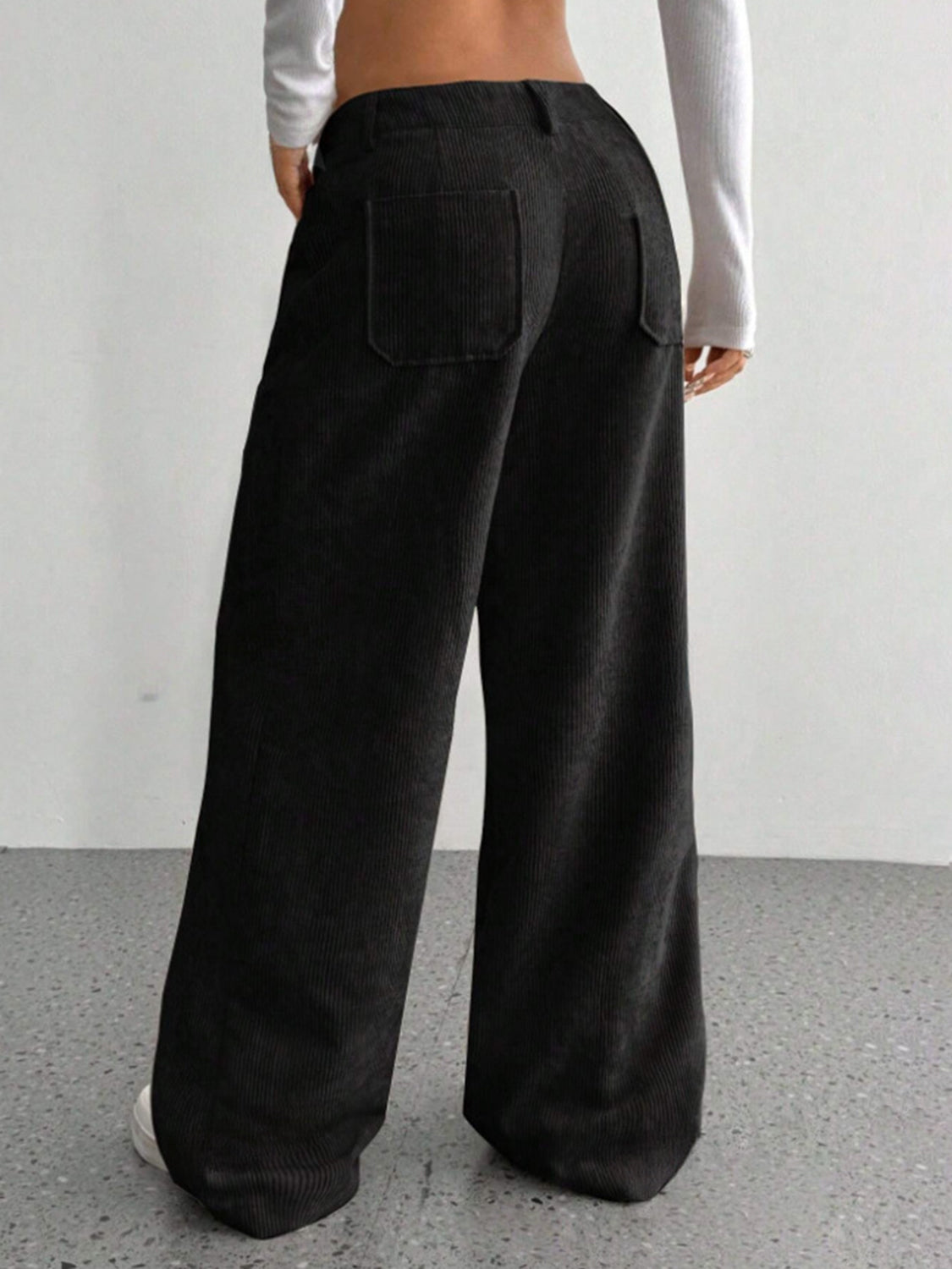 Black corduroy wide-leg utility trousers with back pockets.