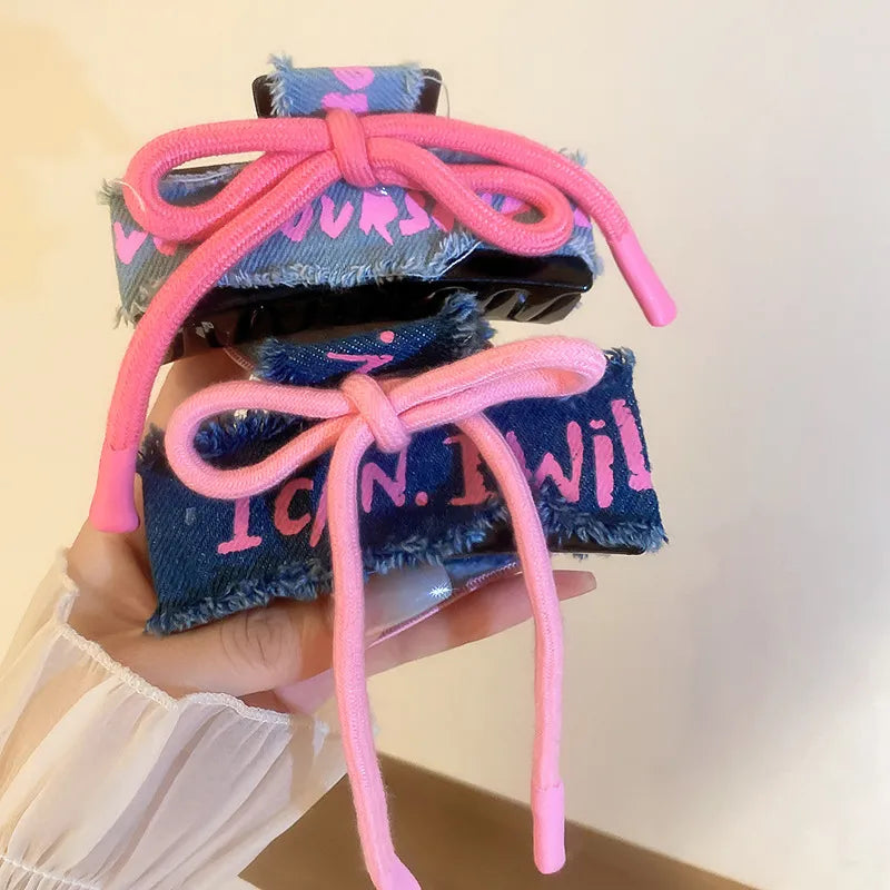Denim patchwork claw clip with pink drawcord and bow detail.